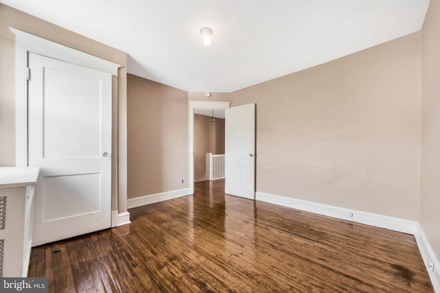 unfurnished bedroom featuring hardwood / wood-style floors and baseboards