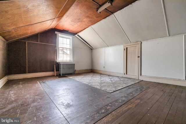 additional living space featuring radiator, vaulted ceiling, and hardwood / wood-style flooring