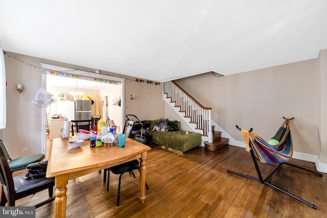 interior space featuring hardwood / wood-style flooring, stairway, baseboards, and a chandelier