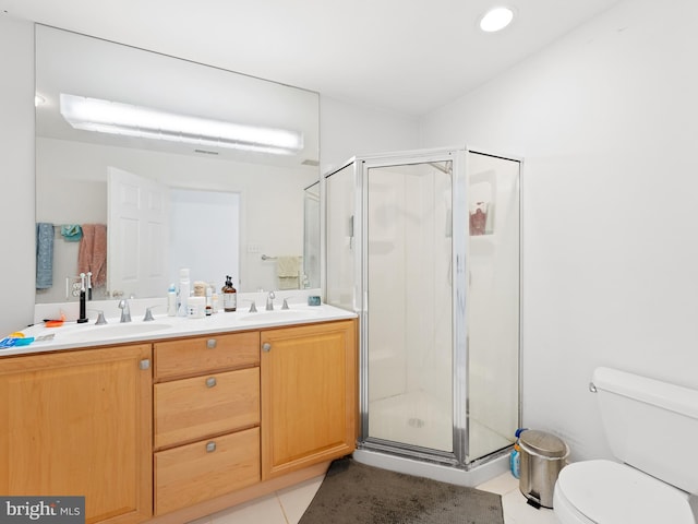 full bath with double vanity, a shower stall, toilet, and a sink