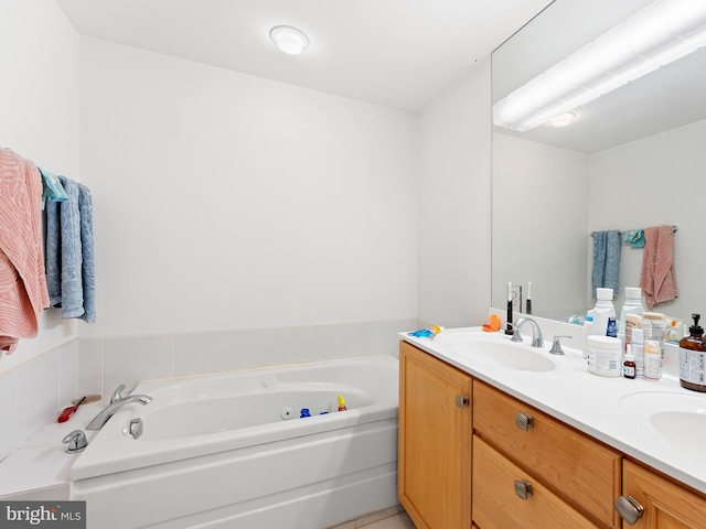 bathroom featuring double vanity, a garden tub, and a sink