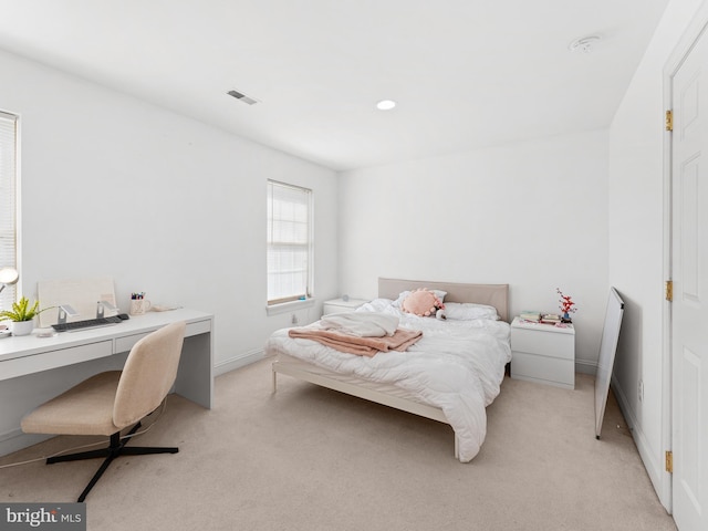 bedroom with visible vents, light colored carpet, and baseboards