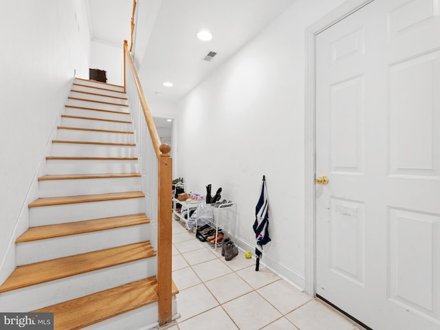 stairway with recessed lighting, visible vents, baseboards, and tile patterned flooring