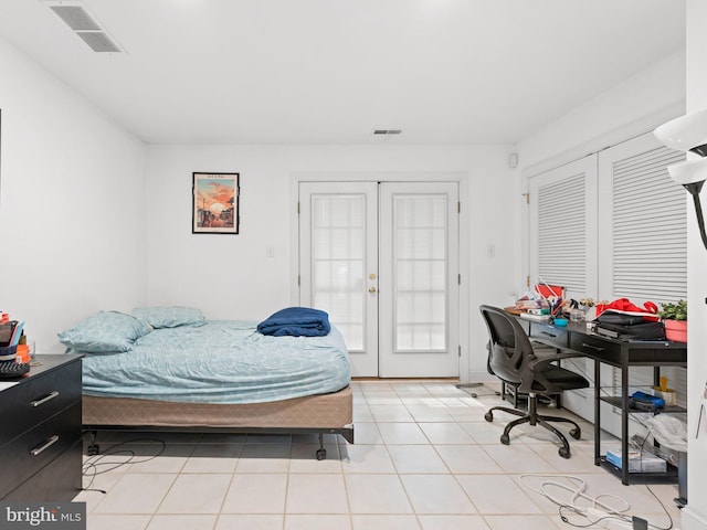 bedroom with light tile patterned floors, visible vents, and french doors