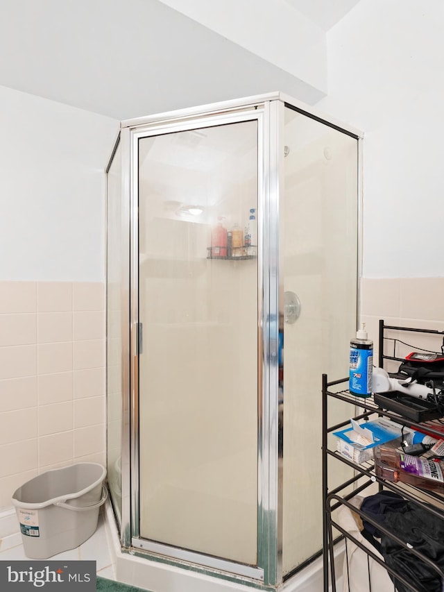 bathroom with tile walls and a stall shower