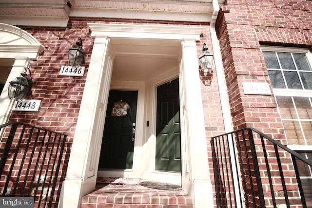 doorway to property featuring brick siding