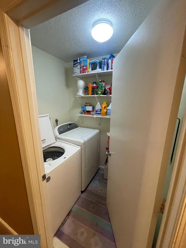 washroom with laundry area, independent washer and dryer, and a textured ceiling