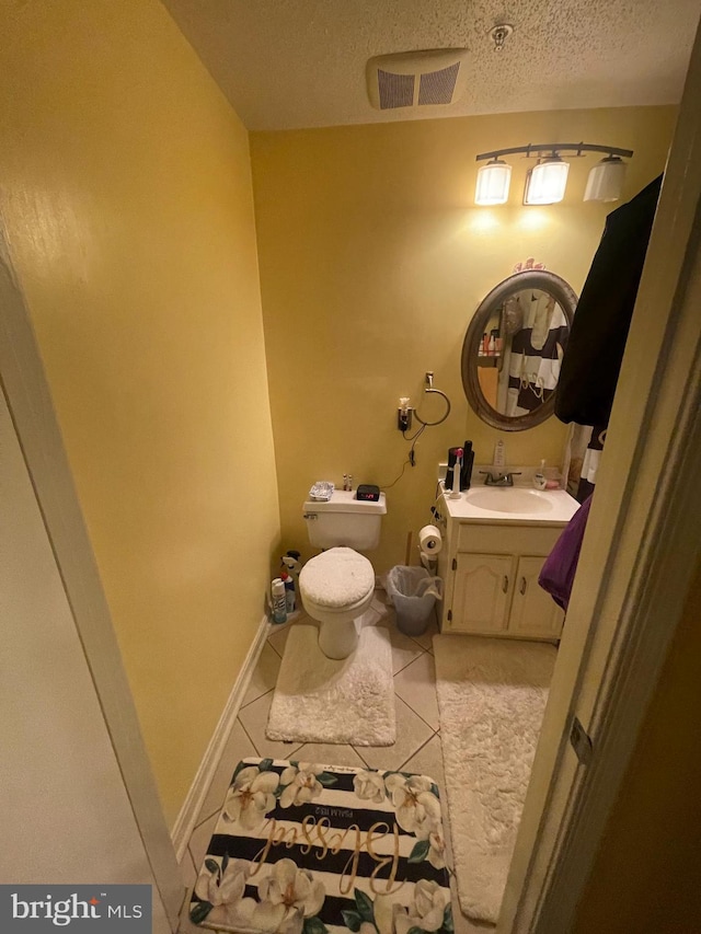 bathroom featuring vanity, visible vents, tile patterned flooring, a textured ceiling, and toilet