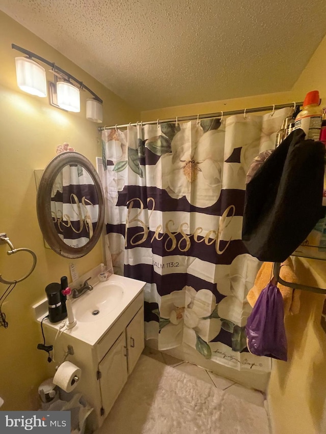 full bath featuring a shower with shower curtain, a textured ceiling, and vanity