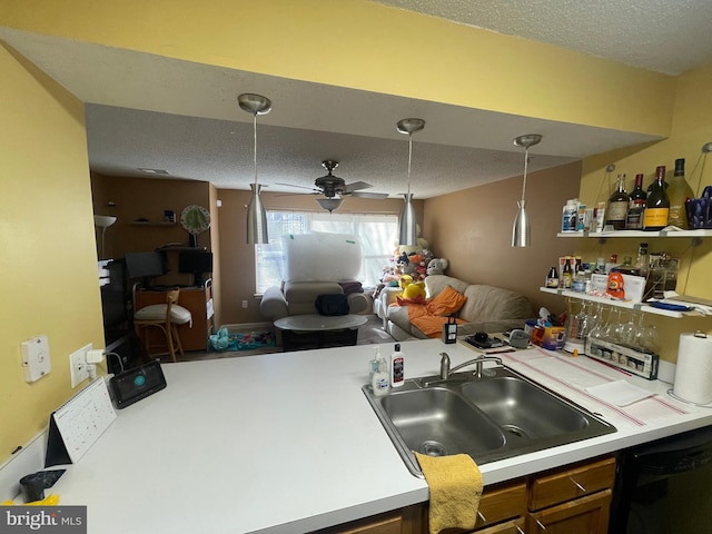 kitchen featuring a sink, dishwashing machine, a textured ceiling, and light countertops