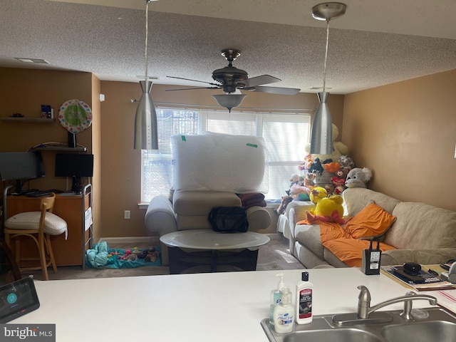 living room featuring a wealth of natural light, visible vents, a textured ceiling, and a ceiling fan