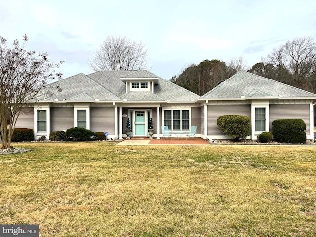 view of front of property with a front lawn and roof with shingles