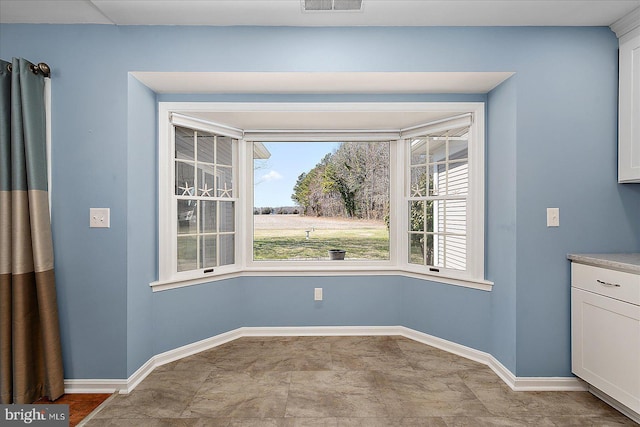 unfurnished dining area with visible vents and baseboards