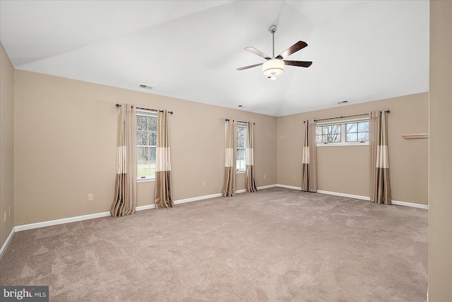 empty room with visible vents, lofted ceiling, ceiling fan, and carpet flooring