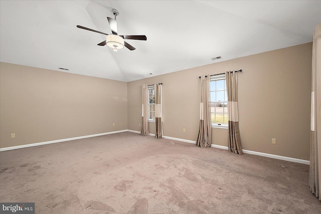 empty room featuring visible vents, baseboards, lofted ceiling, and a ceiling fan