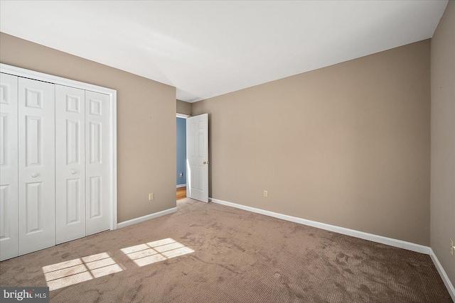 unfurnished bedroom with carpet, baseboards, and a closet