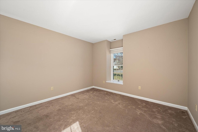 empty room featuring baseboards and carpet floors