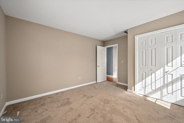 unfurnished bedroom featuring baseboards, a closet, and carpet floors