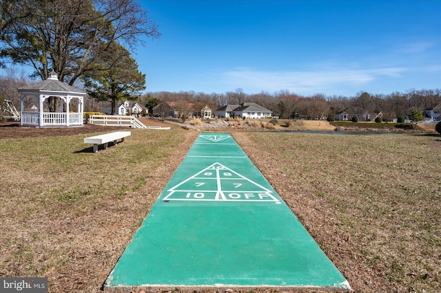 view of community featuring a gazebo, shuffleboard, and a yard