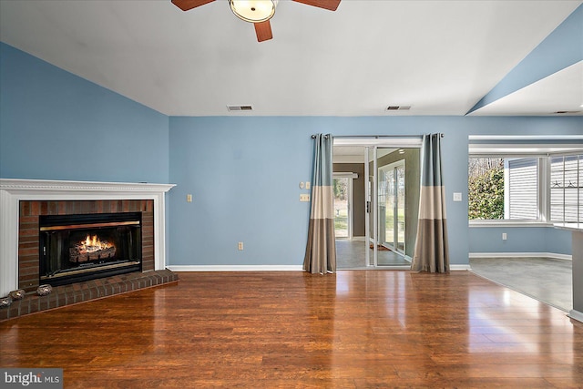 unfurnished living room with baseboards, wood finished floors, visible vents, and ceiling fan