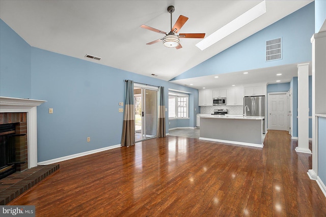 unfurnished living room featuring visible vents, baseboards, ceiling fan, dark wood finished floors, and a fireplace