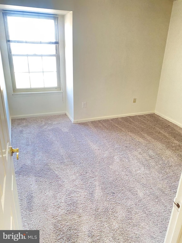 carpeted empty room with baseboards