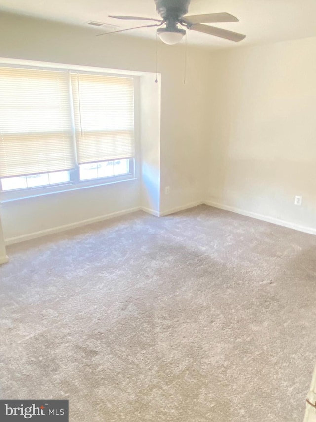 spare room with ceiling fan, carpet flooring, and baseboards