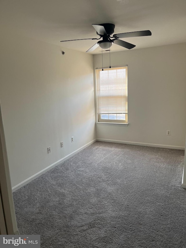 carpeted empty room featuring ceiling fan and baseboards