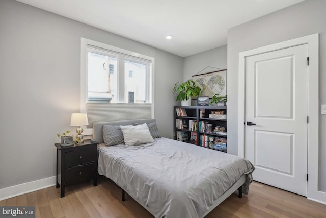 bedroom with light wood-type flooring and baseboards