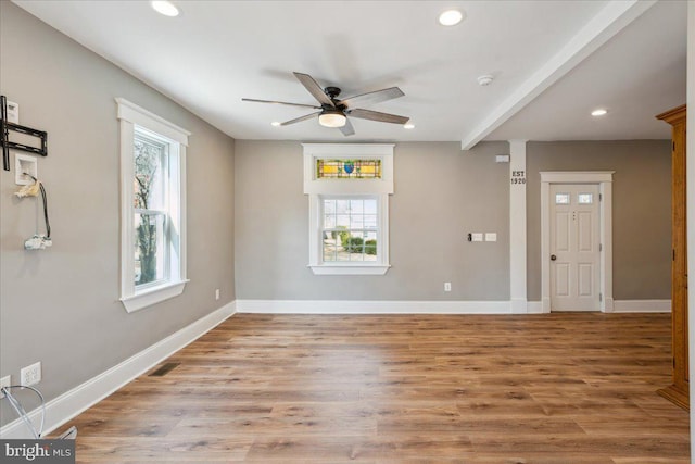 unfurnished room featuring baseboards, wood finished floors, and recessed lighting