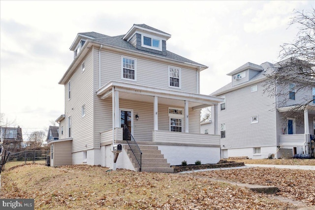 traditional style home featuring a porch and fence