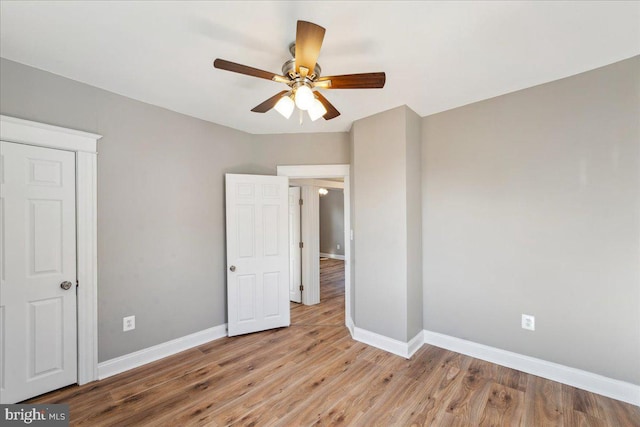 unfurnished bedroom with light wood-style floors, baseboards, and a ceiling fan