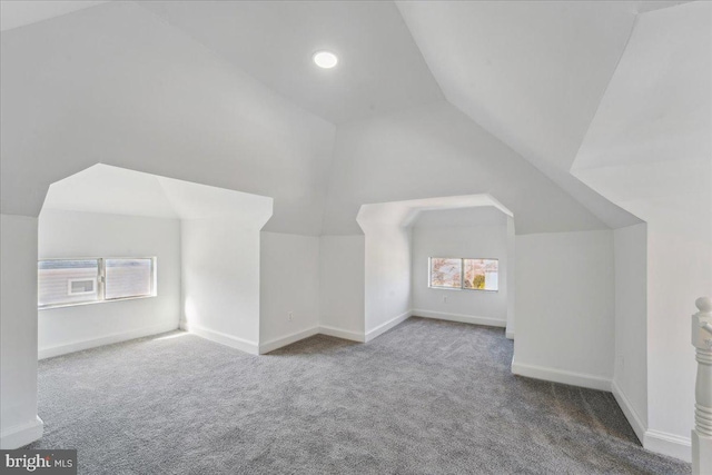 bonus room featuring lofted ceiling, carpet, and baseboards