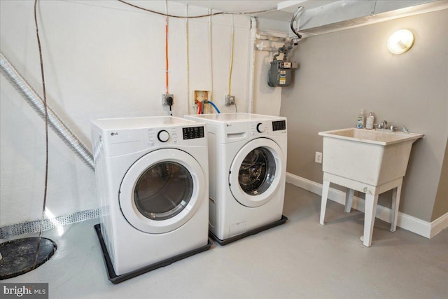 laundry room with separate washer and dryer and baseboards