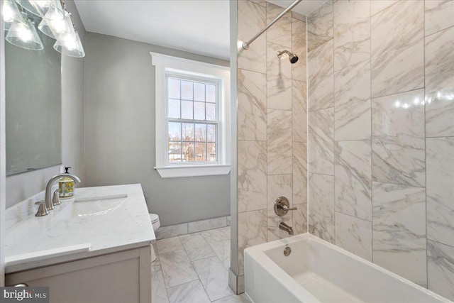 bathroom with toilet, marble finish floor,  shower combination, and vanity