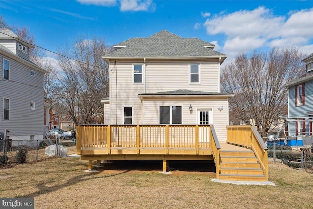 rear view of property with a deck, a yard, roof with shingles, and fence