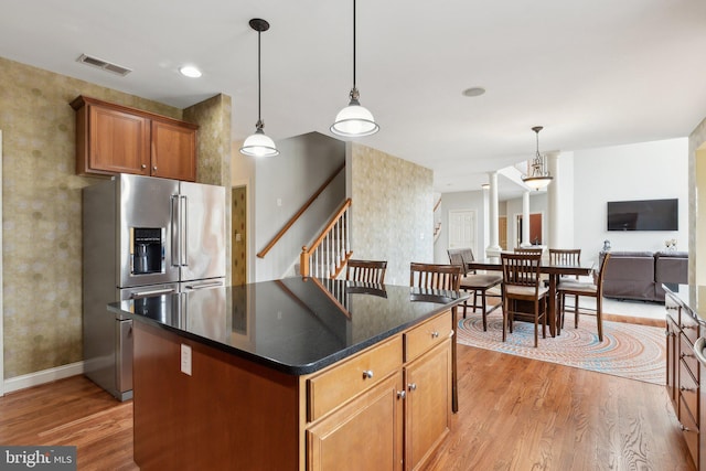 kitchen with light wood finished floors, visible vents, pendant lighting, and stainless steel fridge with ice dispenser