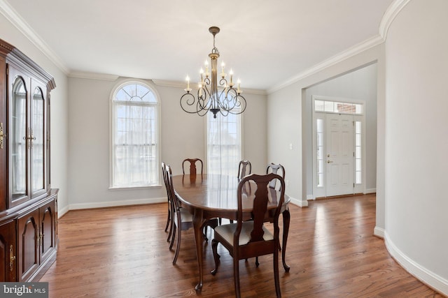 dining room with crown molding, light wood finished floors, and a chandelier