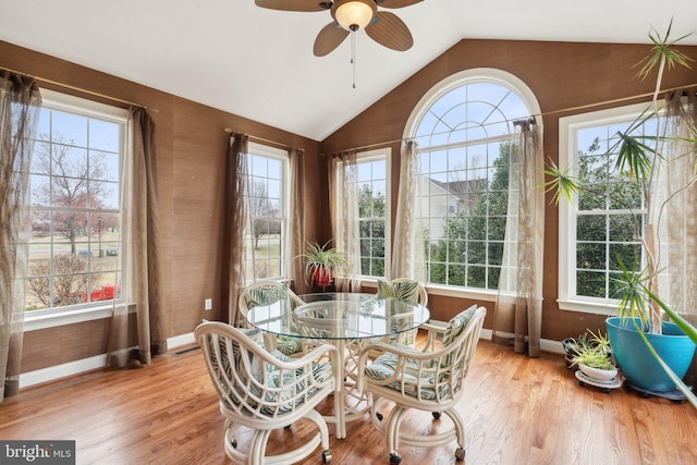 sunroom / solarium featuring vaulted ceiling, plenty of natural light, visible vents, and ceiling fan