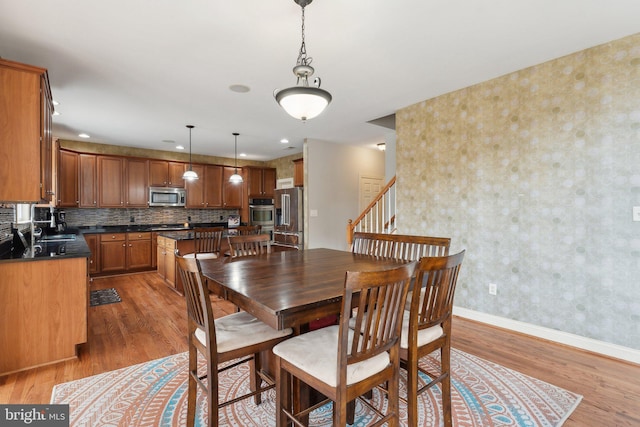 dining room with baseboards and light wood finished floors