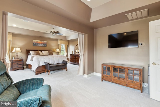 bedroom featuring a tray ceiling, visible vents, light carpet, and baseboards