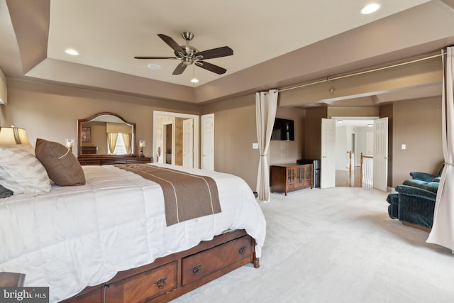 bedroom featuring recessed lighting, light carpet, a raised ceiling, and ceiling fan