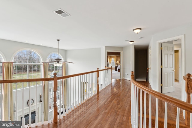 hall featuring visible vents, baseboards, and light wood-style floors