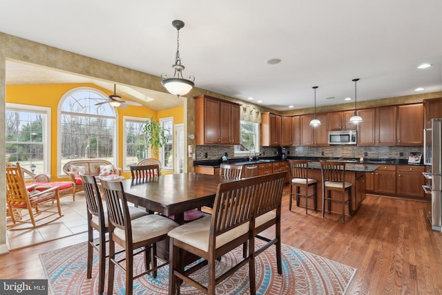 dining space with recessed lighting, a ceiling fan, and wood finished floors