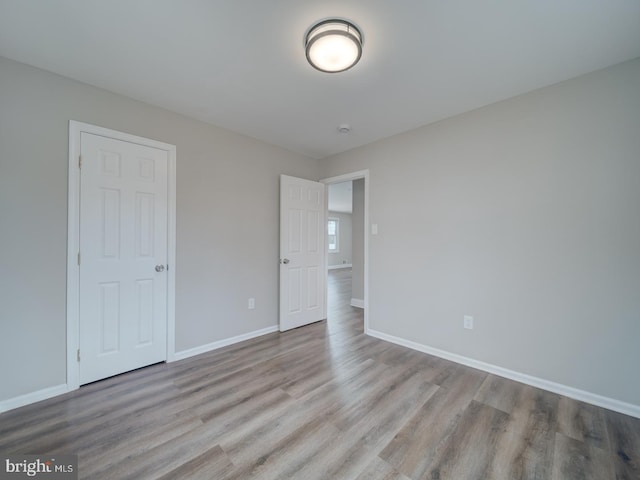 unfurnished bedroom with baseboards and wood finished floors