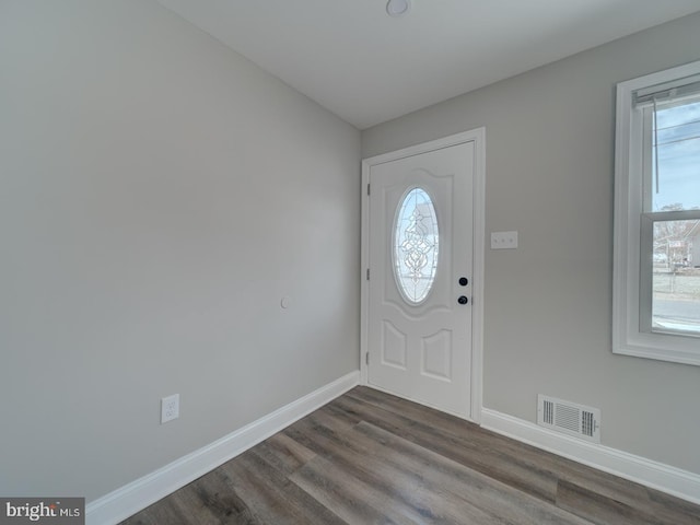 foyer featuring dark wood finished floors, visible vents, and baseboards