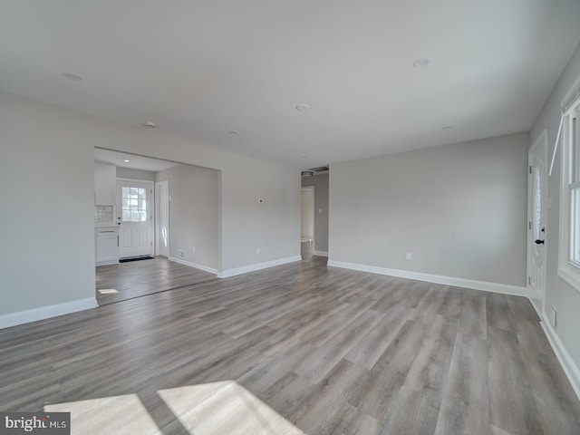 unfurnished living room with light wood-style flooring and baseboards