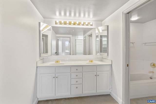 bathroom featuring double vanity, baseboards, and a sink