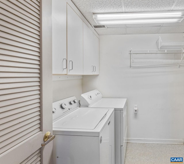 clothes washing area featuring visible vents, separate washer and dryer, cabinet space, and baseboards