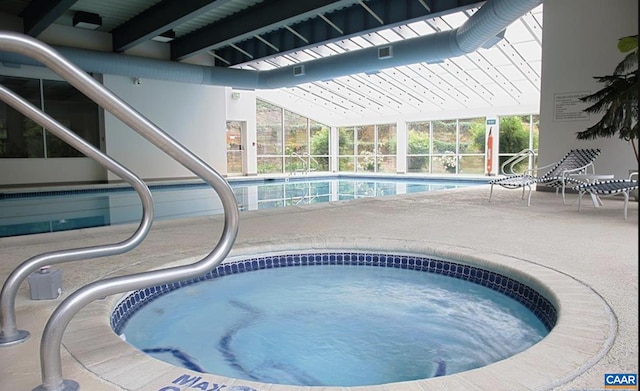 community pool with an indoor hot tub, a patio area, and a lanai